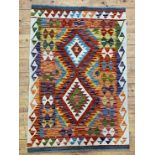 A Chobi kilim rug of all over geometric design with a running dog border 123cm x 82cm