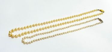 A cream coloured cultured graduated stand of pearls with oval ribbed 9ct gold clasp fastening, (L