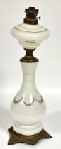 A late 19thc continental milk glass floral swag decorated baluster oil lamp base with cast brass