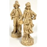 A pair of Edwardian continental porcelain musician travelling figures both dressed in early 19thc