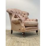 A Victorian style button back armchair, upholstered in pink damask fabric, raised on turned supports