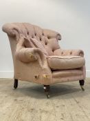 A Victorian style button back armchair, upholstered in pink damask fabric, raised on turned supports