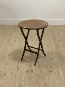 A small Edwardian mahogany coaching table, the circular folding top raised on slender supports H53cm