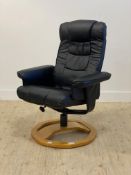 A Contemporary faux black leather upholstered lounge chair, with reclining back rest and raised on a