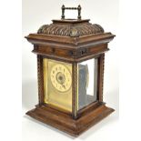 A late 19thc German musical four glass walnut carved table clock, with brass handle to fluted hinged