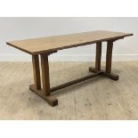 An Arts and Crafts period oak refectory type dining table, the recatangular top raised on four