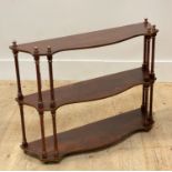 A Regency style parcel gilt and scumbled three height wall shelf, each tier of serpentine outline on