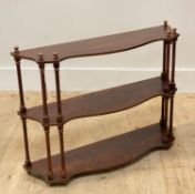 A Regency style parcel gilt and scumbled three height wall shelf, each tier of serpentine outline on