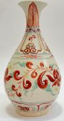 A Chinese/Japanese earthenware vase with polychrome decoration depicting scrolling floral motifs and