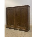 An early to mid 20th century oak cupboard, two panelled doors enclosing three shelves to interior,