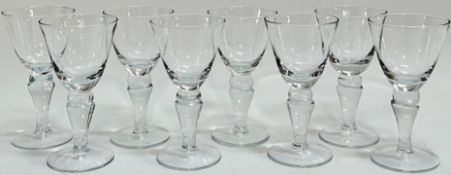 A set of eight clear drinking glasses on knopped stems (h- 16cm), together with an etched glass