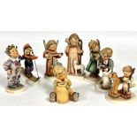 A collection of eight Hummel German pottery figures including, Carnival, Skier, Angel Serenade,