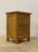 A contemporary oak bedside table, fitted with three drawers, raised on stile supports H66cm,