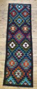 A Maimana kilim runner with repeating lozenges on a dark field 208cm x 61cm