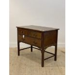 An Edwardian mahogany side table, fitted with two short and one long drawer, raised on moulded