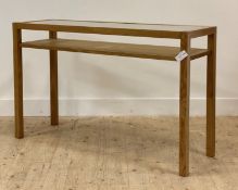A contemporary oak console table, the top with inset glass panel raised on square section supports