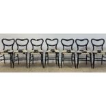 A set of seven Victorian ebonised dining chairs, with open kidney backs over upholstered seats and