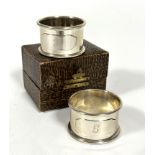 A pair of Birmingham silver napkin rings with shaped panels to front engraved with R and G in fitted