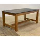A large kitchen dining table, the granite top raised on pale ash square section supports united by