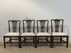 A set of four Georgian mahogany dining chairs, with undulating crest rail above a pierced splat