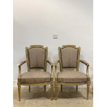 A pair of Regency style gilt framed arm chairs, with upholstered back and seat, raised on turned,