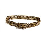 A Edwardian 15ct gold gate link bracelet with oval bead barrel central panels and safety chain, (D x