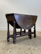 An 18th century oak gateleg table, the oval double drop leaf top raised on ring turned and block