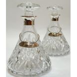 A pair of cut crystal glass decanters with hallmarked silver tops and hallmarked silver decanter