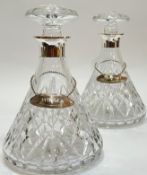 A pair of cut crystal glass decanters with hallmarked silver tops and hallmarked silver decanter