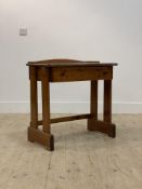 A varnished pine and mahogany side table, with ledge back over drawer, raised on four panel supports