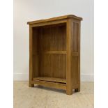 A contemporary oak open bookcase, fitted with two adjustable shelves, raised on stile supports