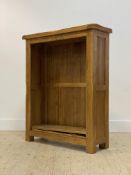 A contemporary oak open bookcase, fitted with two adjustable shelves, raised on stile supports
