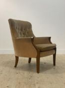A Victorian style button back armchair, with yellow velvet upholstery, raised on tapered supports