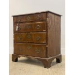 An 18th century walnut chest of small proportions, the top with moulded edge above four cross banded