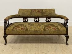 An Edwardian mahogany salon settee, the upholstered crest rail and overstuffed seat raised on