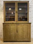 A late 19th century stained pine estate bookcase on cupboard, the twin glazed doors encloing three