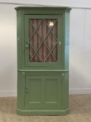 A 19th century painted pine two part corner cabinet, with astragal glazed door enclosing two