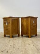 A pair of contemporary oak bedside tables, each fitted with three drawers, raised on stile