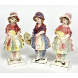 Katzhuttee, a group of three porcelain figures of girls in bonnets, a pair holding a bouquet of