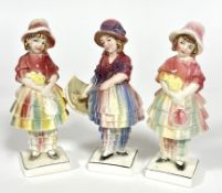 Katzhuttee, a group of three porcelain figures of girls in bonnets, a pair holding a bouquet of