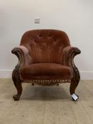 A Victorian walnut framed armchair, upholstered in buttoend velvet, with scroll carved show frame,