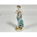 A Continental Meissen style porcelain figure of a lady with floral decorated top and turquoise skirt