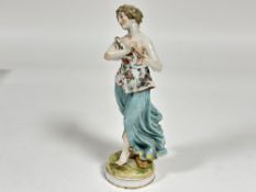 A Continental Meissen style porcelain figure of a lady with floral decorated top and turquoise skirt