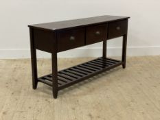 A stained hardwood console table, fitted with three drawers over square tapered supports united by a