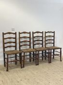 A set of four early 20th century stained oak ladder back chairs, with rush seats and turned supports