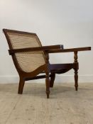 A teak framed planters type chair, with sweeping bergere seat and back rest, raised on turned