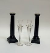 A pair of wooden black painted corinthian column style candle sticks (h-31.5cm) together with a pair