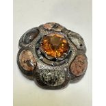 A white metal Scottish style shaped brooch set central amber faceted glass style stone enclosed with