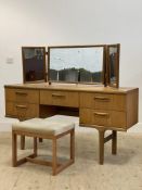 A mid century teak dressing table, with triple swing mirror above one long and four short drawers,