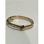 An Edwardian 9ct gold buckle engraved hinged bangle with engraved inscription, dated 1903, (D x